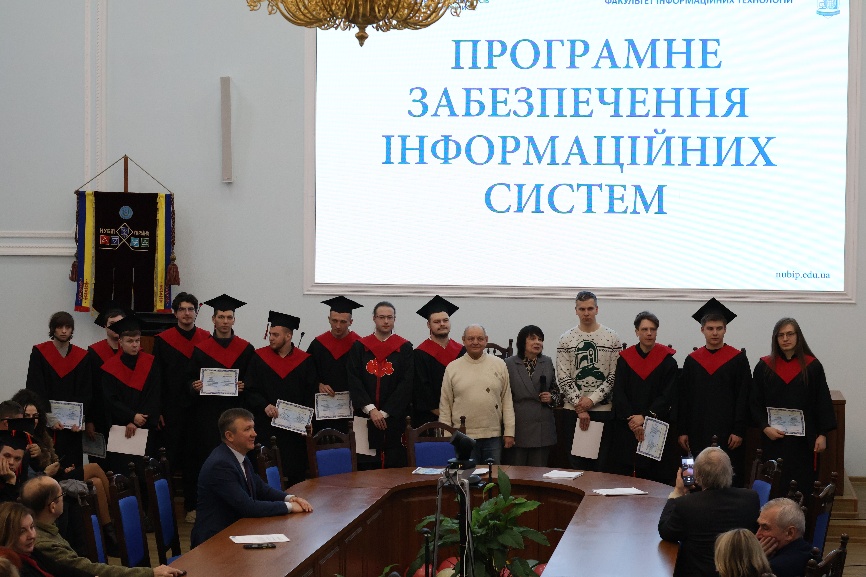 A group of people standing in a room</p>
<p>AI-generated content may be incorrect.